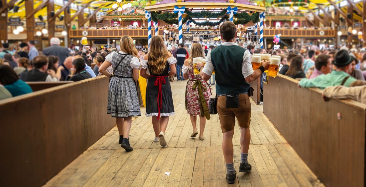 Oktoberfest, Munich, Germany. Waiter holding beers, tent interior background